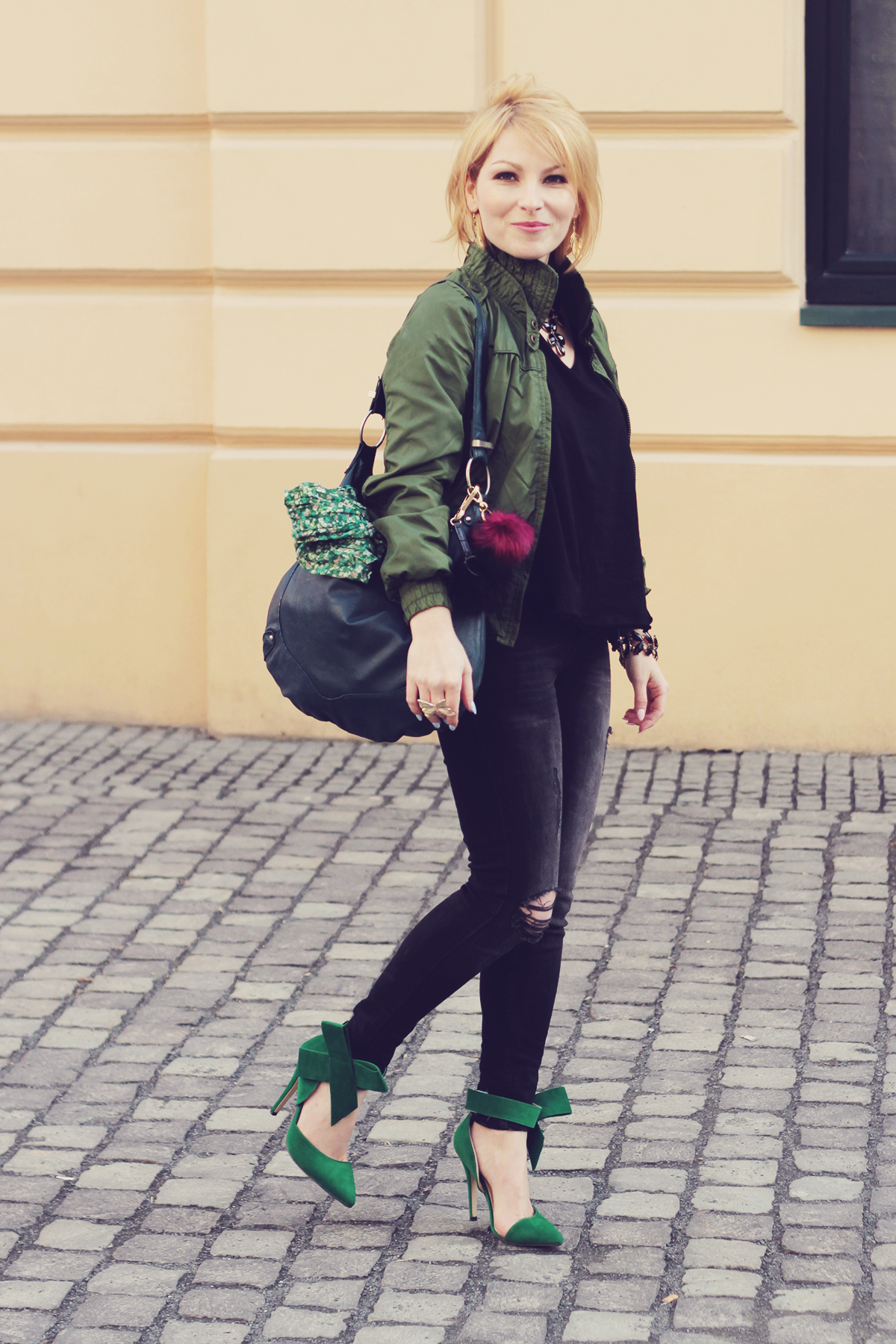 green bomber jacket with jeans and big bow heels