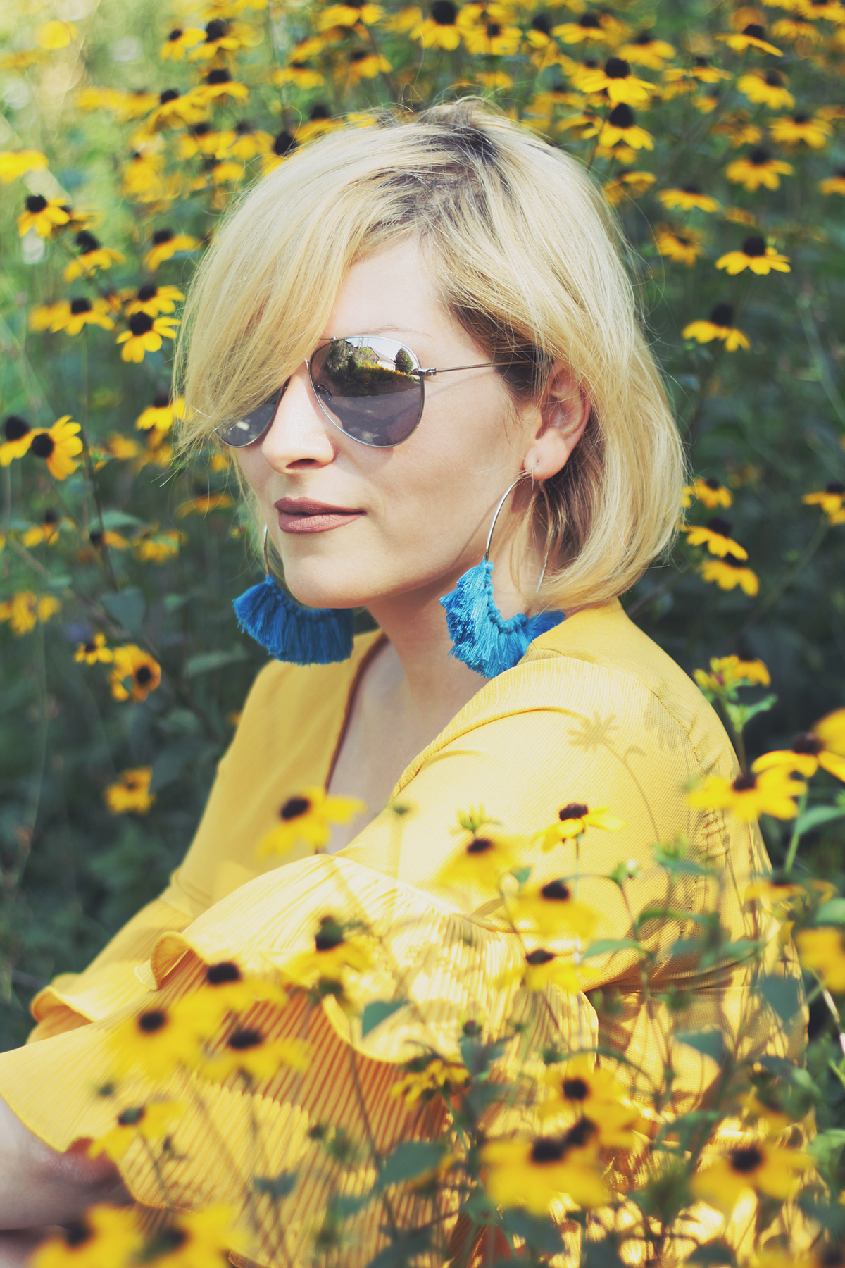 yellow ruffle top, blue tassel earrings, nature, yellow flowers