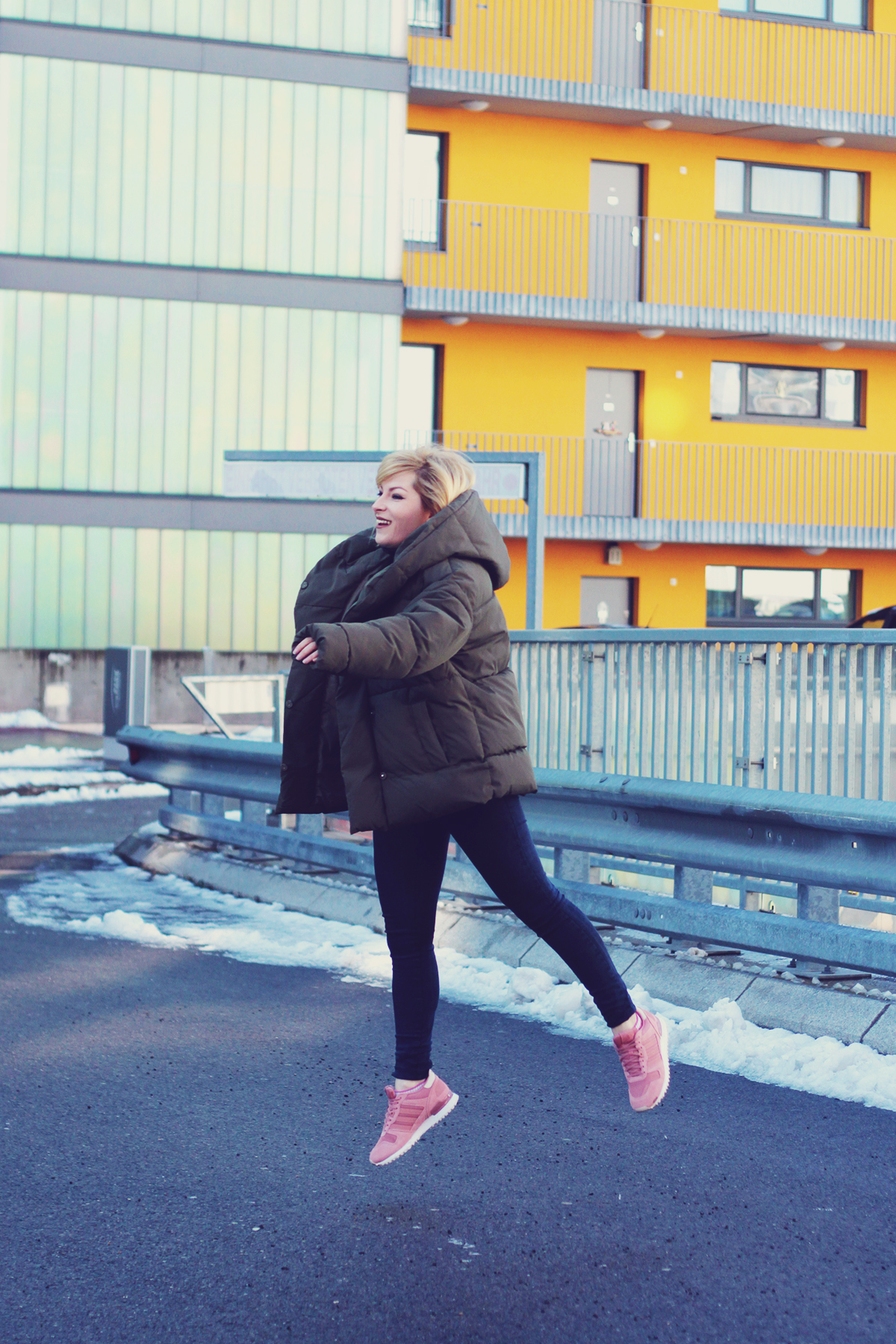 winter fashion, padded jacket, jeans, pink adidas originals, girl jumping, urban landscape, Vienna, snow
