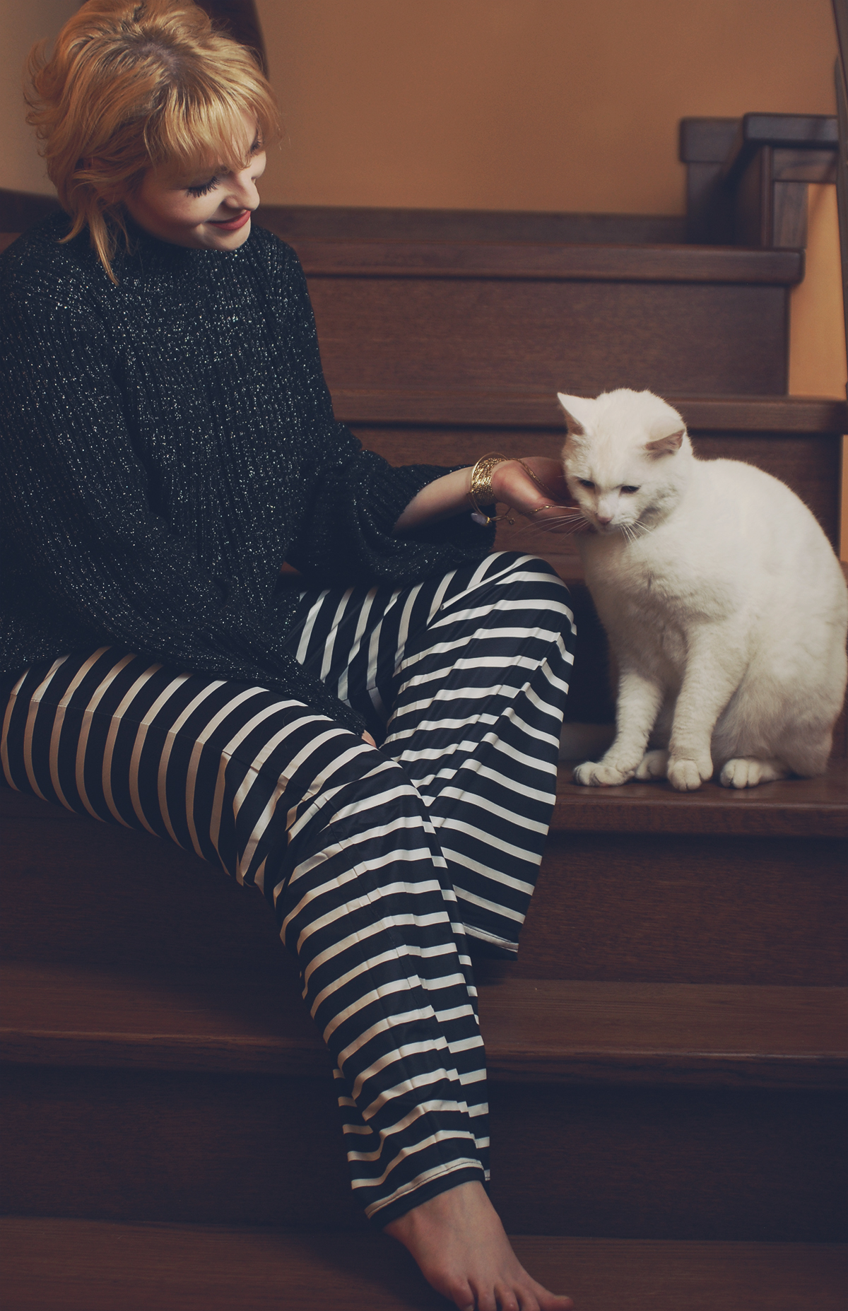 Dior vintage necklace worn as a bracelet, Rosegal stone bracelet, black sparkly sweater, black and white striped flare pants, short blonde bob with bangs, white cat, cute, lounging at home