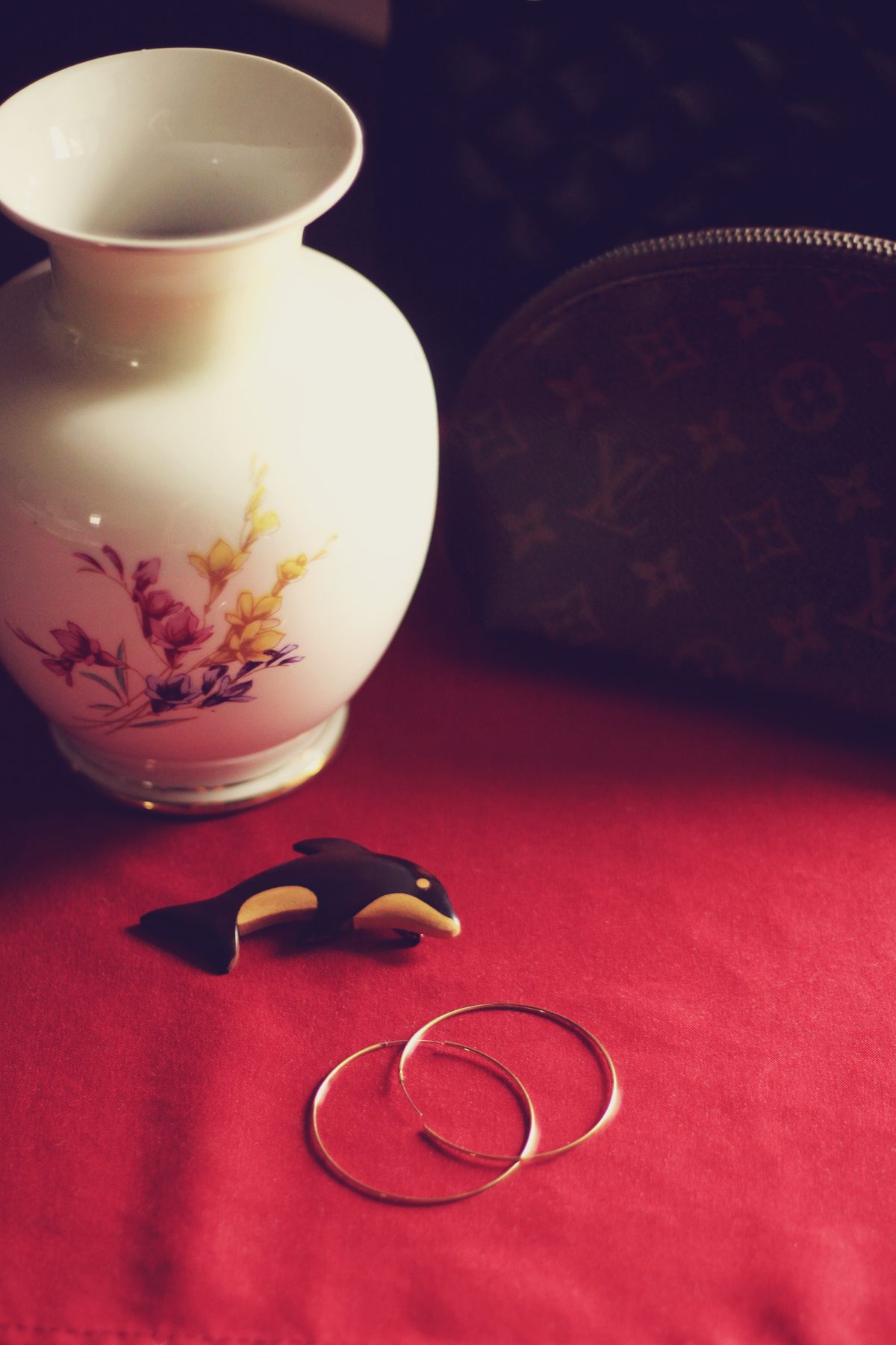 hoop earrings, dolphin brooch, louis vuitton travel pouch, vintage porcelain vase, old mansion