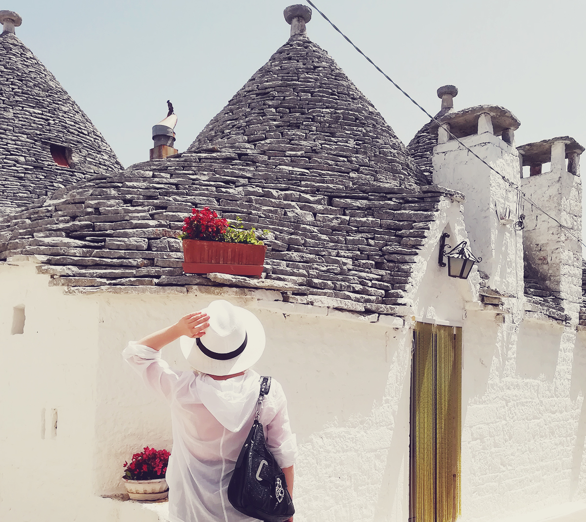Alberobello, Italy, travel, travel tips, beautiful trulli buildings, white Summer hat, Motivi top, Guess bag