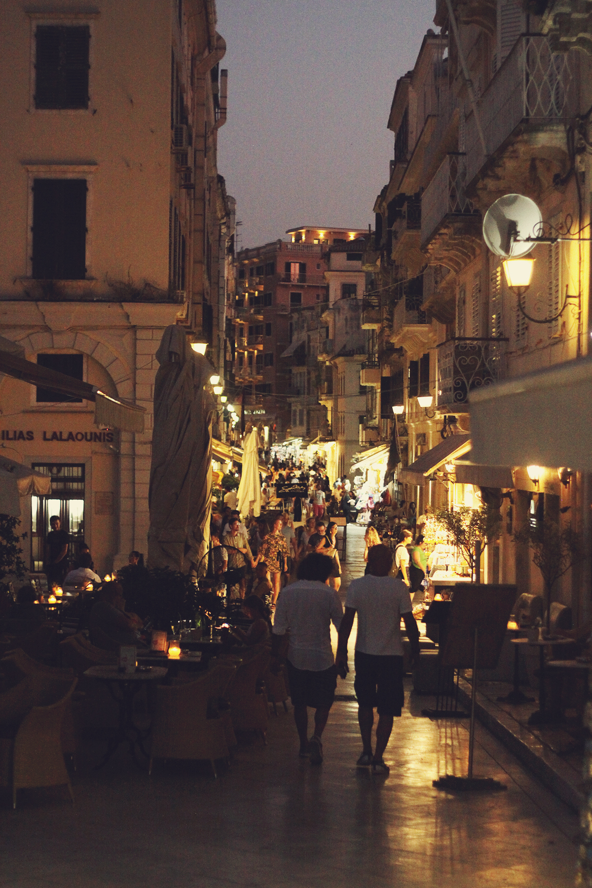 Corfu Town by night, busy narrow street, travel post